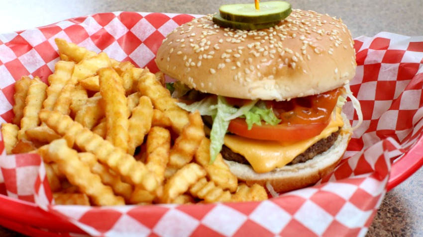 Our burger and seasoned crinkle-cut fries in a red basket.
